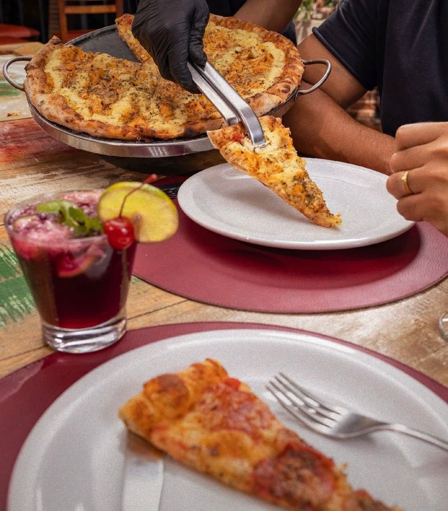 Pizza sendo servida na mesa do restaurante